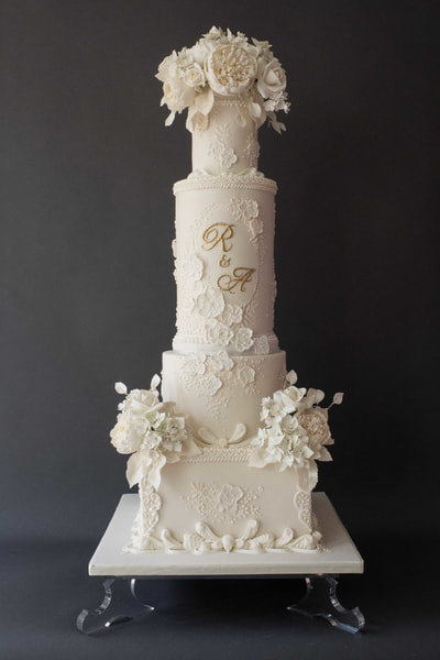 From a wedding at Cheshire's Peckforton Castle, this all white wedding cake design was inspired by the bride's beautifully seductive Pronovias wedding dress. 