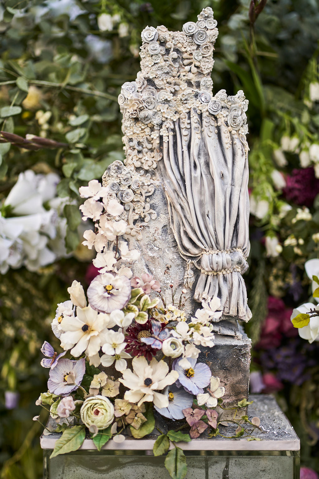 stunning 4 tier stone wedding cake with stone flower detailing, gold leaf, and sugar flowers