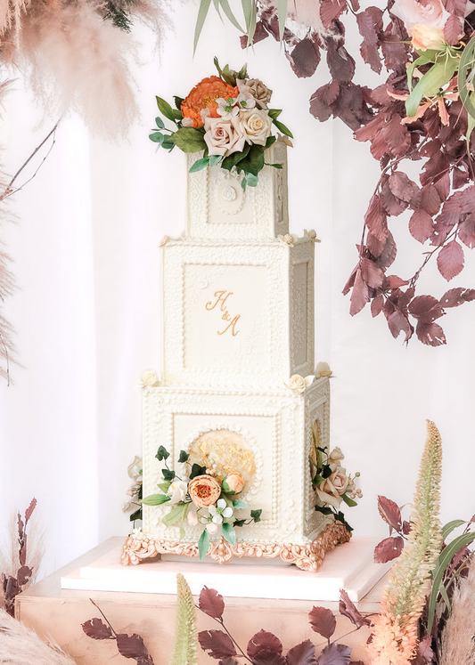 3 tier white square classical wedding cake with gold monogram, white texture details and sugar flowers 38