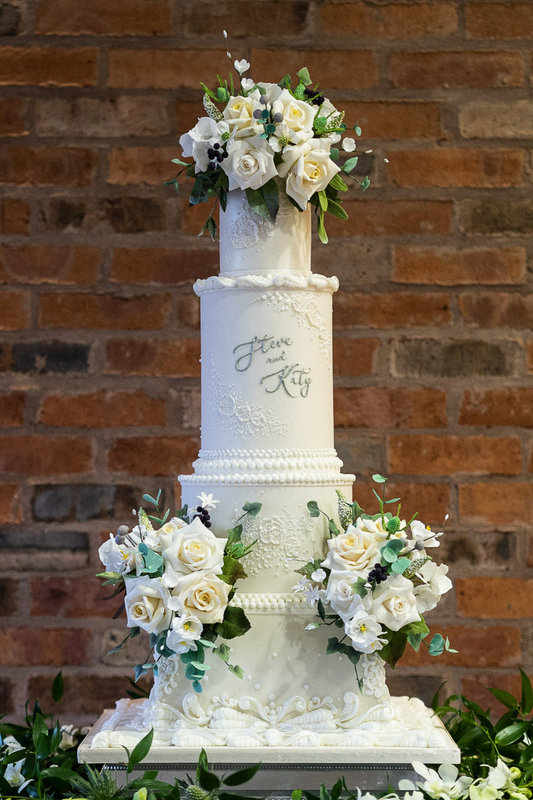 4 tier classic white wedding cake with square base, white textured details, handmade sugar flowers and hand piped names 20