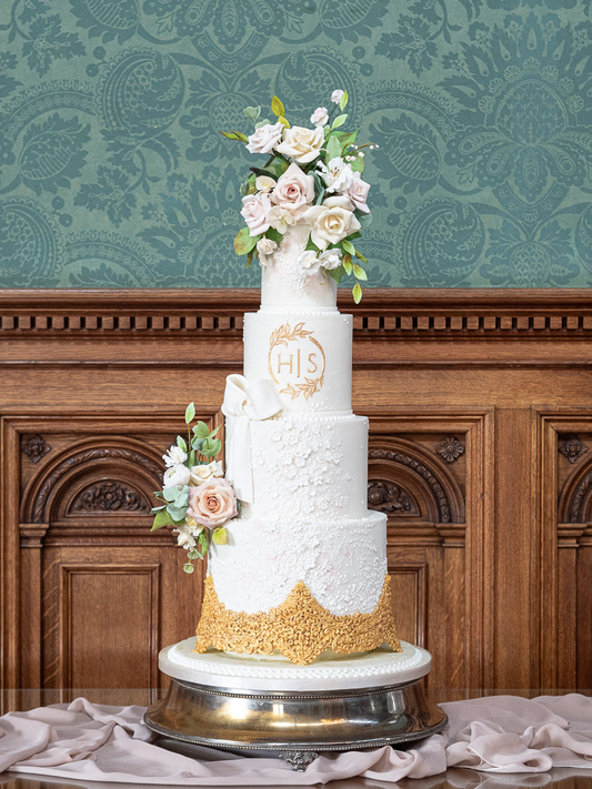 4 tier elegant white wedding cake, textured with hand piped gold details, sugar flowers, sugar bow, and monogram 5