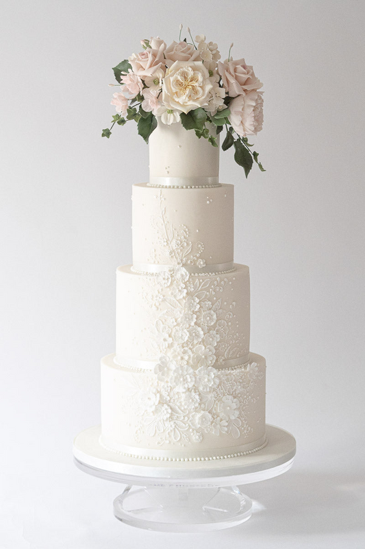 4 tier classical white wedding cake with textured white floral detail and sugar flowers 44