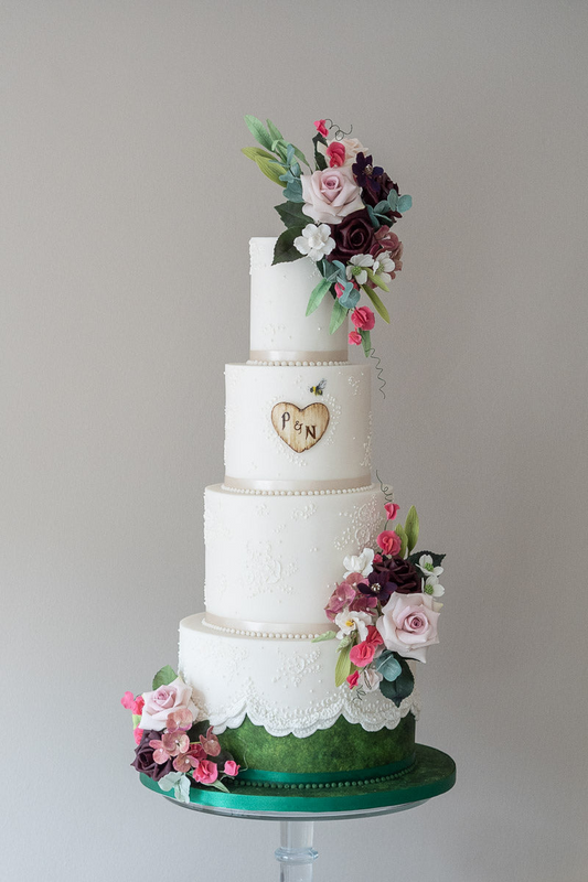 4 tier charming white and green wedding cake with white lace trim, sugar flowers, and heat monogram 35