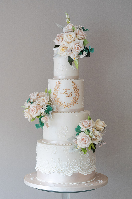 4 tier classic white wedding cake with gold monogram and white lace trim, with sugar flowers 20